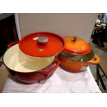 Red cast iron Pyrex lidded pot and another Le Crueset style cast iron pot. Not available for in-