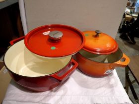 Red cast iron Pyrex lidded pot and another Le Crueset style cast iron pot. Not available for in-