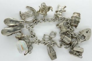 Hallmarked silver charm bracelet with twelve charms, L: 18 cm, 69g. UK P&P Group 1 (£16+VAT for