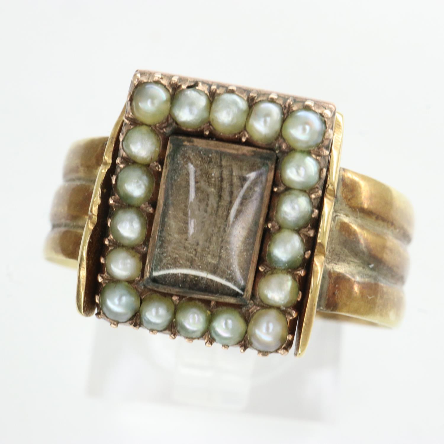 Yellow metal mourning ring containing hair surrounded with seed pearls, inscription to back, size S,