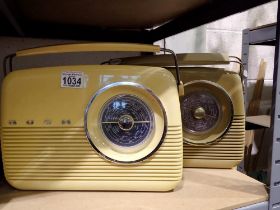 Two Bush radios, model TR82, one blue and one burgundy with cables, working at lotting. All