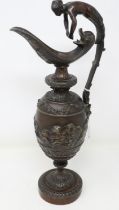 Bronze ornate Greek jug with finial in the form of a lady and cherub decoration in relief, handle