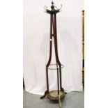 An Edwardian mahogany coat stand, tapering above a large circular base, for restoration. Not