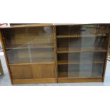 Two mid 20th century bookcases with glass sliding doors, one in the manner of Herbert Gibbs, largest