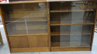 Two mid 20th century bookcases with glass sliding doors, one in the manner of Herbert Gibbs, largest