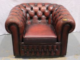 A 20th century ox blood red leather Chesterfield style armchair, damaged to one arm. Not available