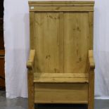 An early 20th century pine settle, with hinged box seat and panelled back rest, split to seat. Not