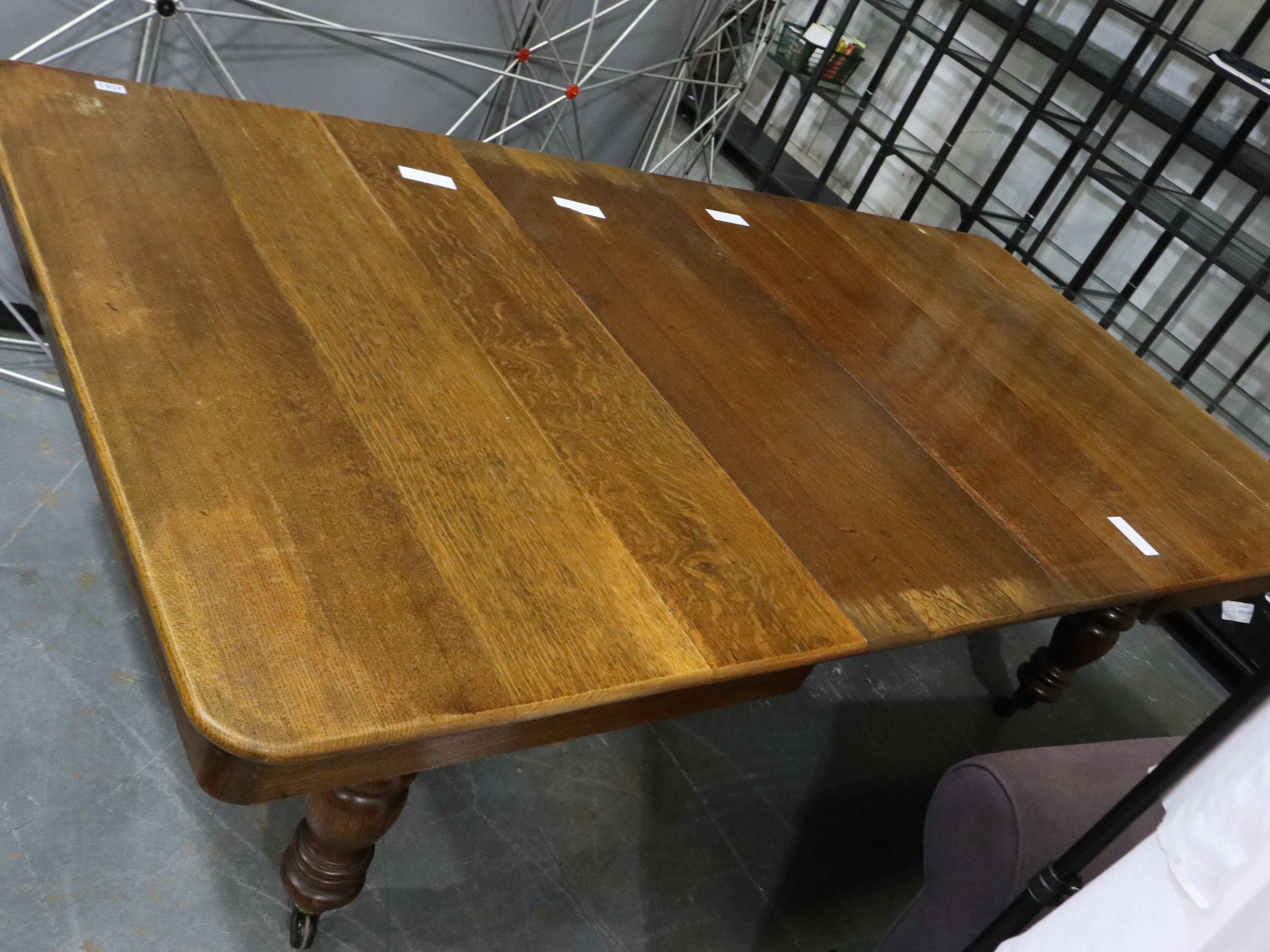A Victorian oak wind out extending dining table with three additional leaves and turned bulbous
