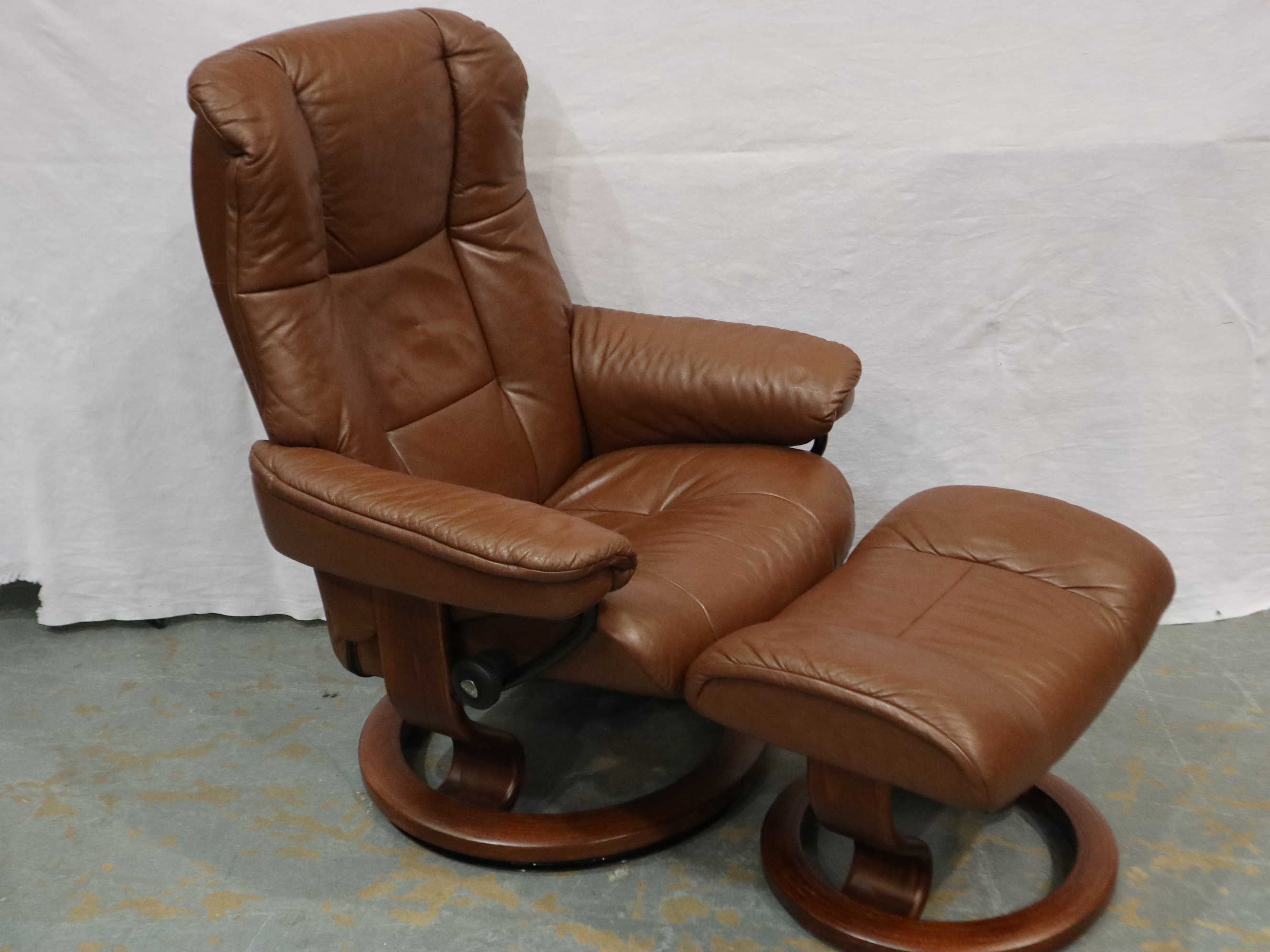 Stressless: A modern brown leather reclining easy chair with footstool. Not available for in-house