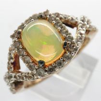925 silver ring with 14ct gold overlay set with cubic zirconia and a central opal, size Q/R, 4.2g.