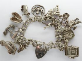 Hallmarked silver charm bracelet with padlock clasp, safety chain and fifteen charms, L: 18 cm, 54g.