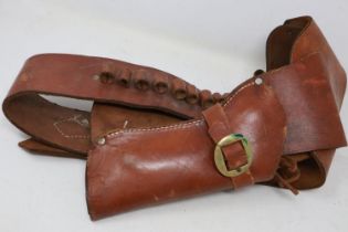 A good quality 20th century Western style tan leather gun belt with holster for Colt 45 or similar