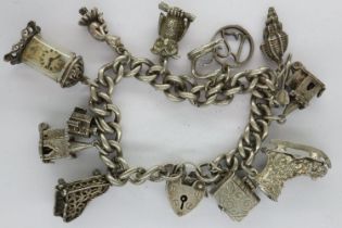 Silver charm bracelet with thirteen charms, padlock clasp and safety chain, L: 18 cm, 63g. UK P&P