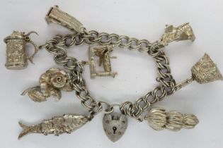 Silver charm bracelet with eight charms and padlock clasp, L: 18 cm. UK P&P Group 1 (£16+VAT for the