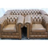 A 20th century tan leather Chesterfield lounge suite comprising a three seat sofa and two armchairs.