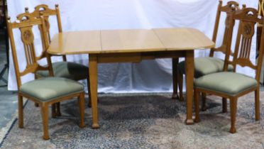 An oak dining suite comprising a drop leaf table and four chairs in the Arts and crafts manner.