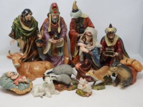 Ceramic nativity set of twelve pieces, losses to horn on cow, small losses to two kings, largest
