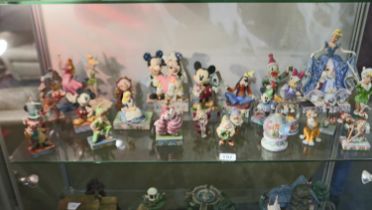 Twenty seven figurines from The Disney Showcase Collection, largest H: 24 cm. Not available for in-