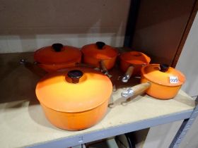 Set of five orange Le Creuset lidded saucepans with holder, 14, 16, 18, 20 and 22. Not available for