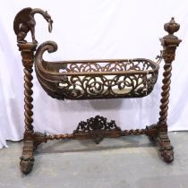 Substantial Victorian gothic bassinet (possibly Black Forest), the boat-form piecework cot suspended