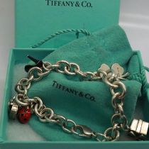 925 silver charm bracelet marked for Tiffany & Co with seven charms, receipt of £141 for the