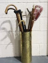 Mixed walking sticks and a shooting stick in a brass holder. UK P&P Group 3 (£30+VAT for the first