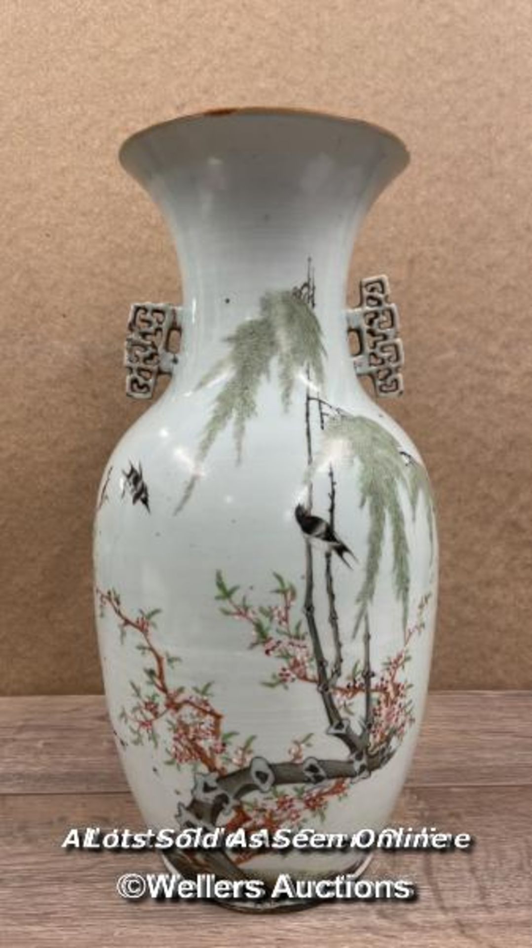 A LARGE JAPANESE VASE DECORATED WITH DETAILED BIRDS AND FLOWERS, DAMAGE TO ONE OF THE FINIALS.