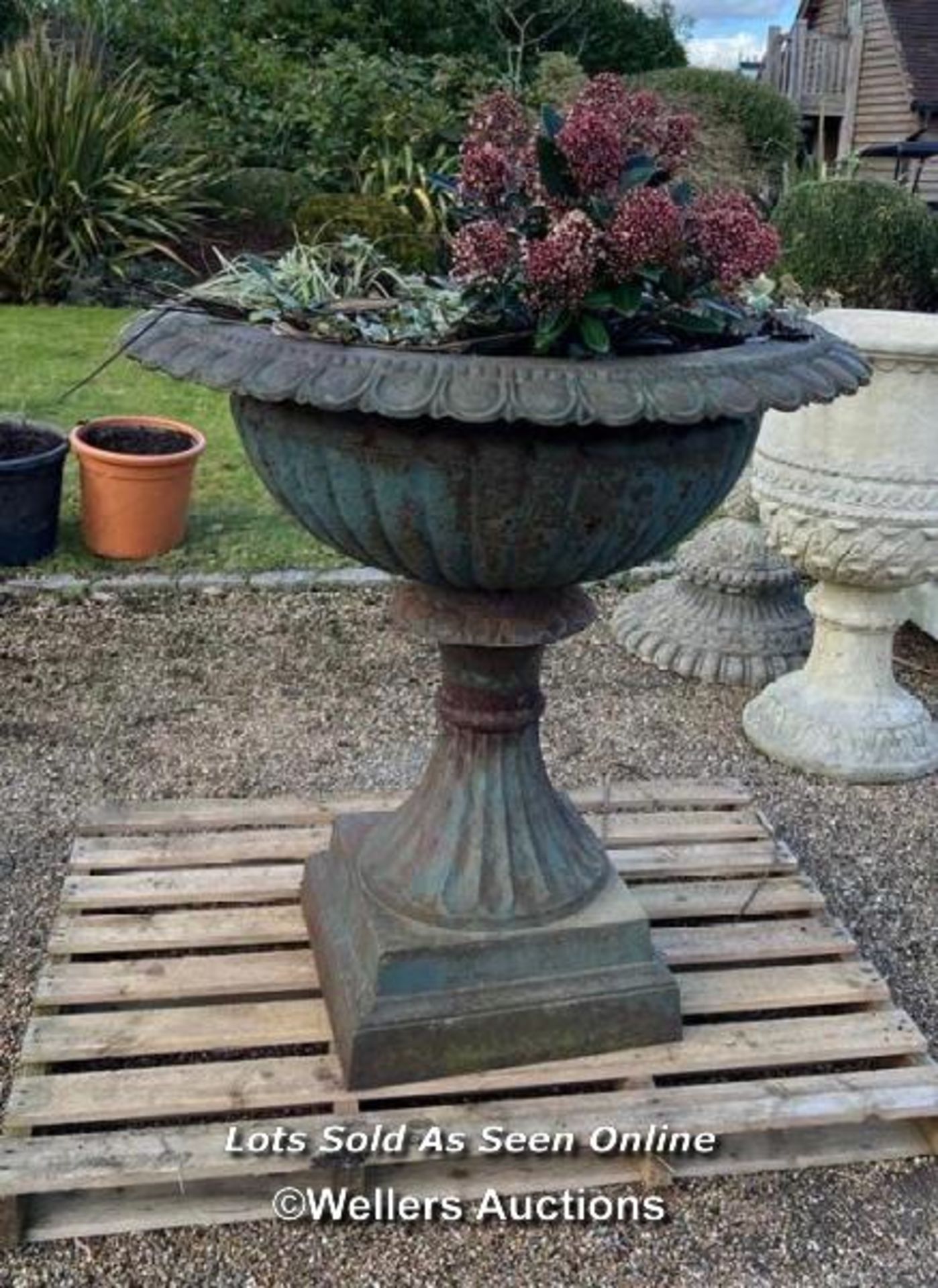 PAIR OF LARGE VICTORIAN STYLE CAST IRON PLANTERS, WITH DECORATIVE ROLL TOP EDGING, ON PLINTH,