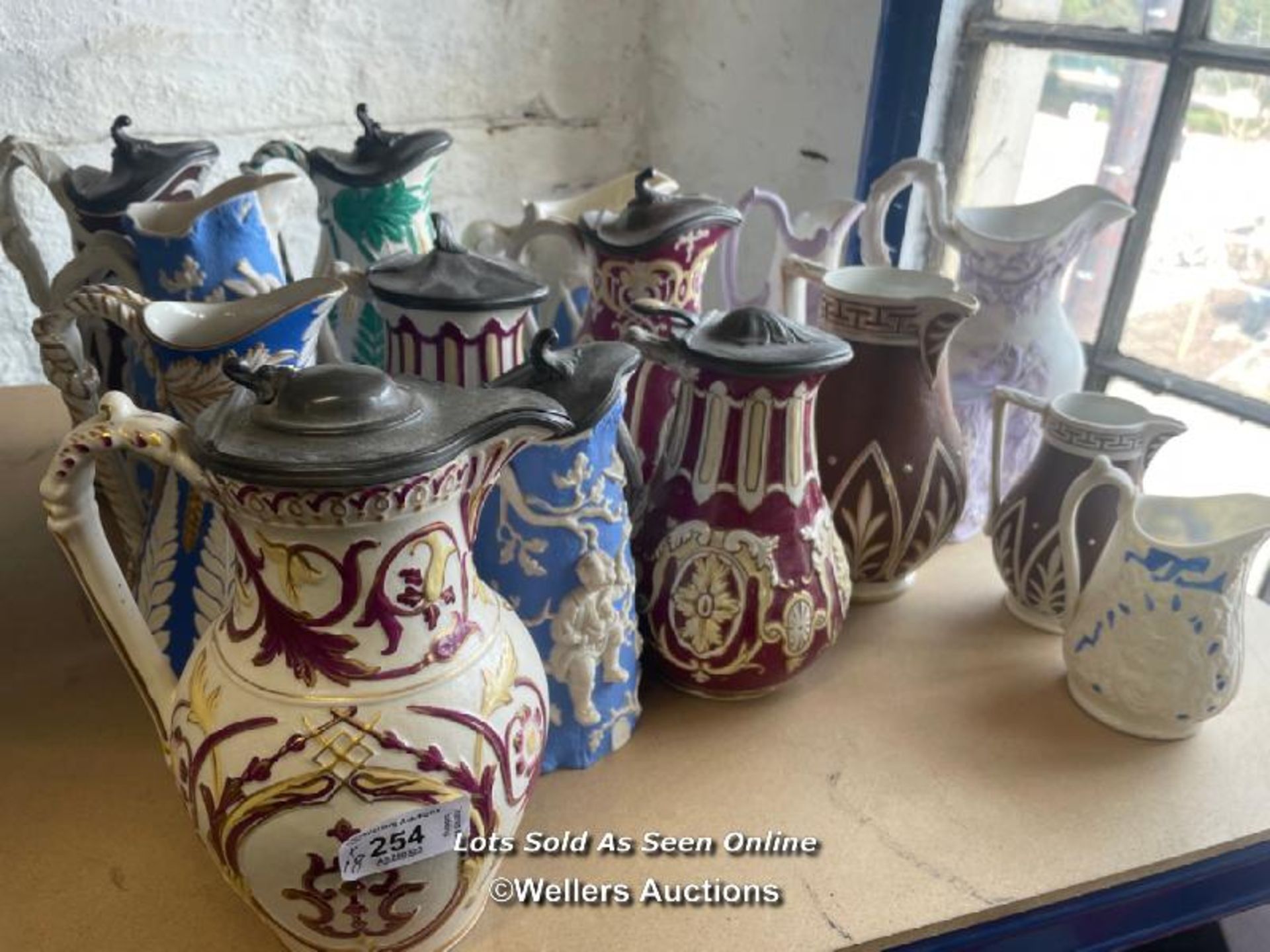 A COLLECTION OF VICTORIAN JUGS, SOME RELIEF MOULDED, SOME WITH LIDS, SOME GRADUATED PAIRS