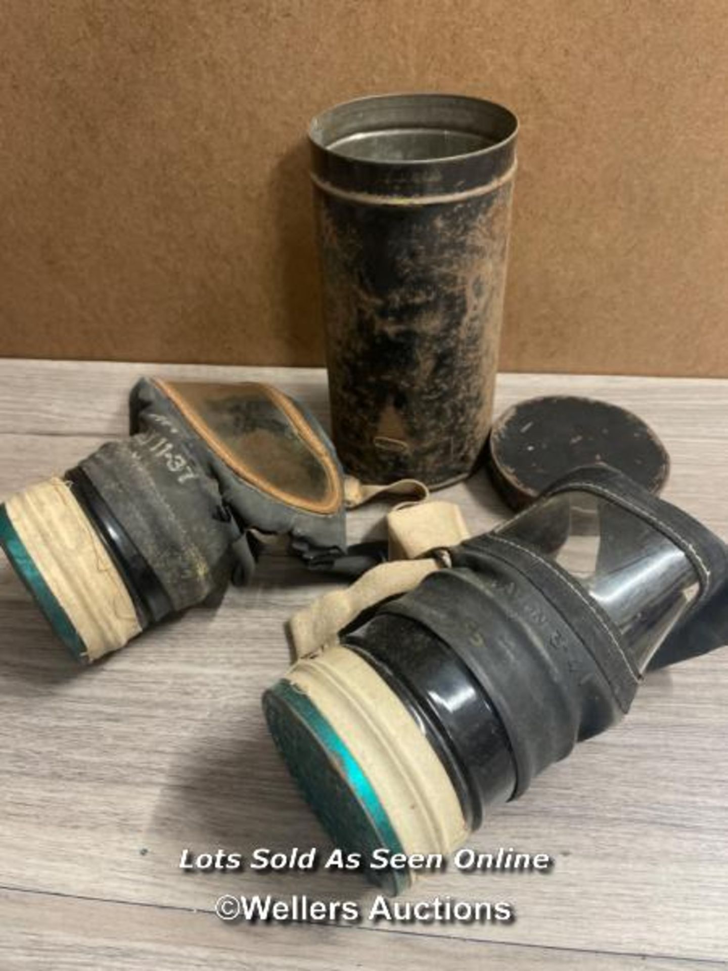 TWO OLD GAS MASKS, ONE IN TIN CONTAINER