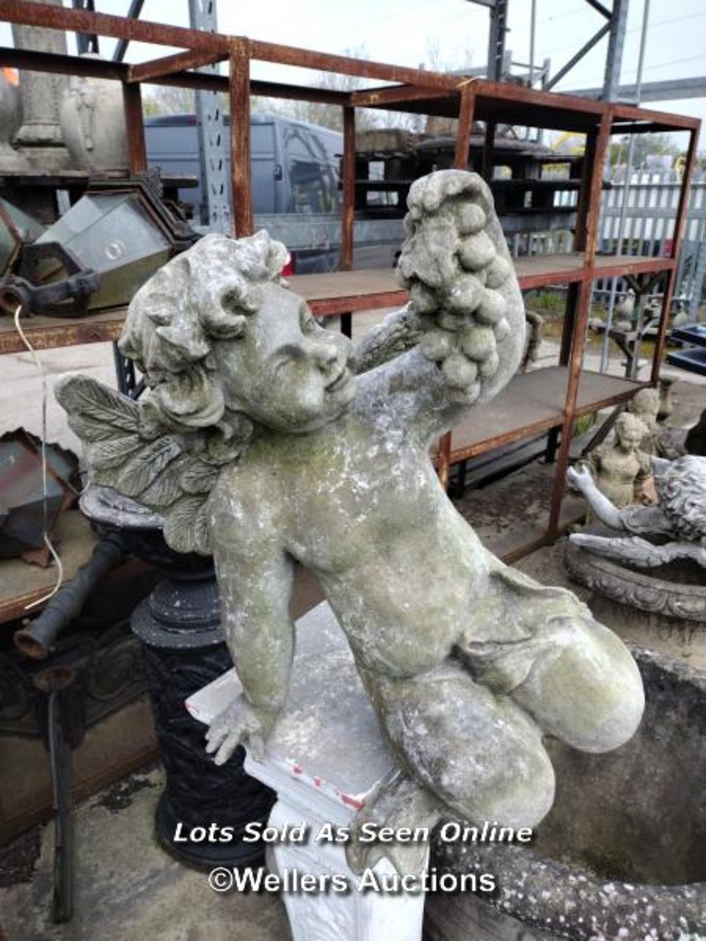 *RECONSTITUTED STONE AND FIBREGLASS CHERUB STATUE, 52CM (H) X 60CM (L), SOME CRACKS AND CHIPS