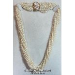 A MULTI ROW NECKLACE OF ELEVEN ROWS OF CULTURED FRESHWATER RICE PEARLS STRUNG TO CLASP SET WITH