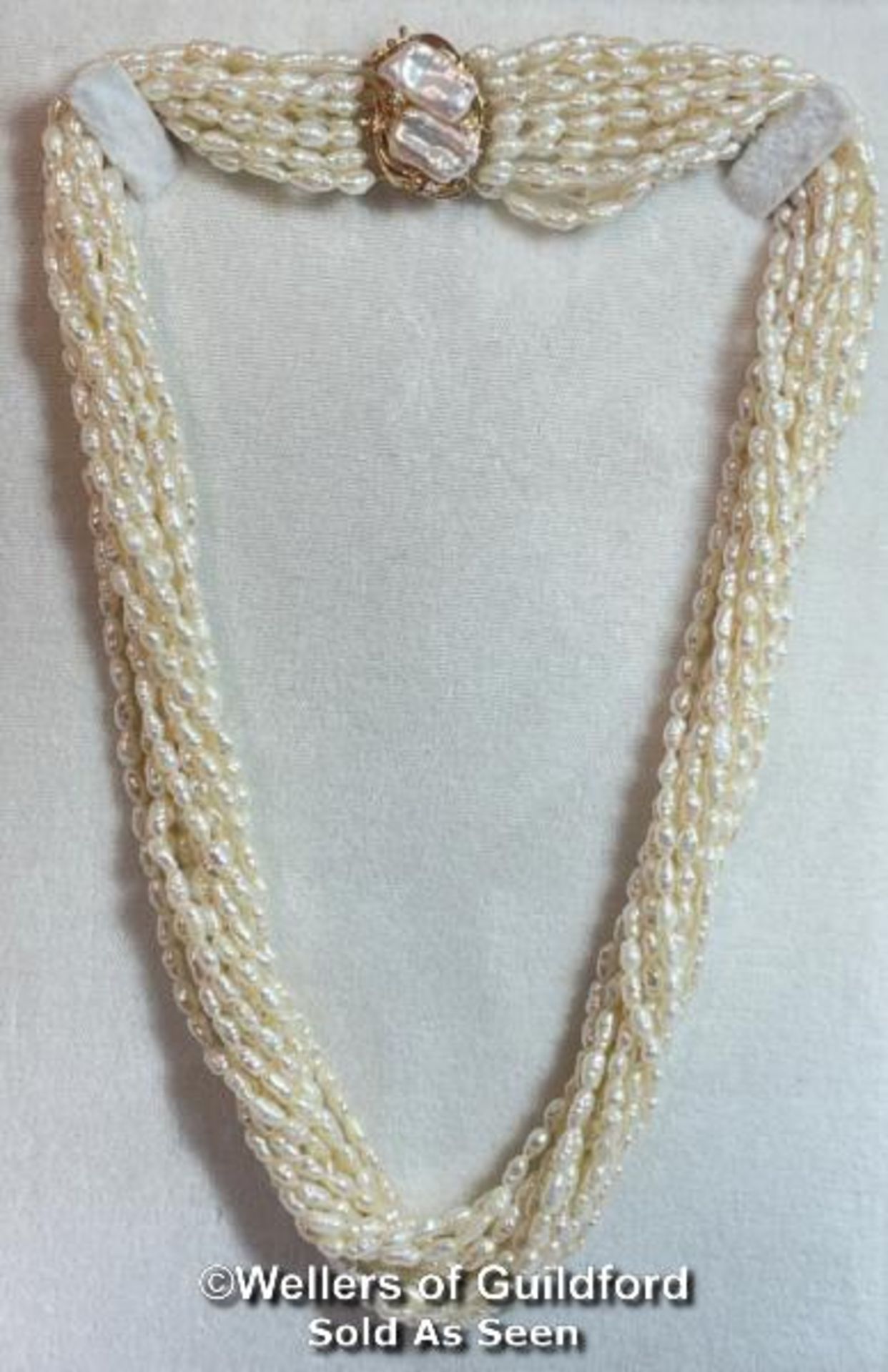 A MULTI ROW NECKLACE OF ELEVEN ROWS OF CULTURED FRESHWATER RICE PEARLS STRUNG TO CLASP SET WITH