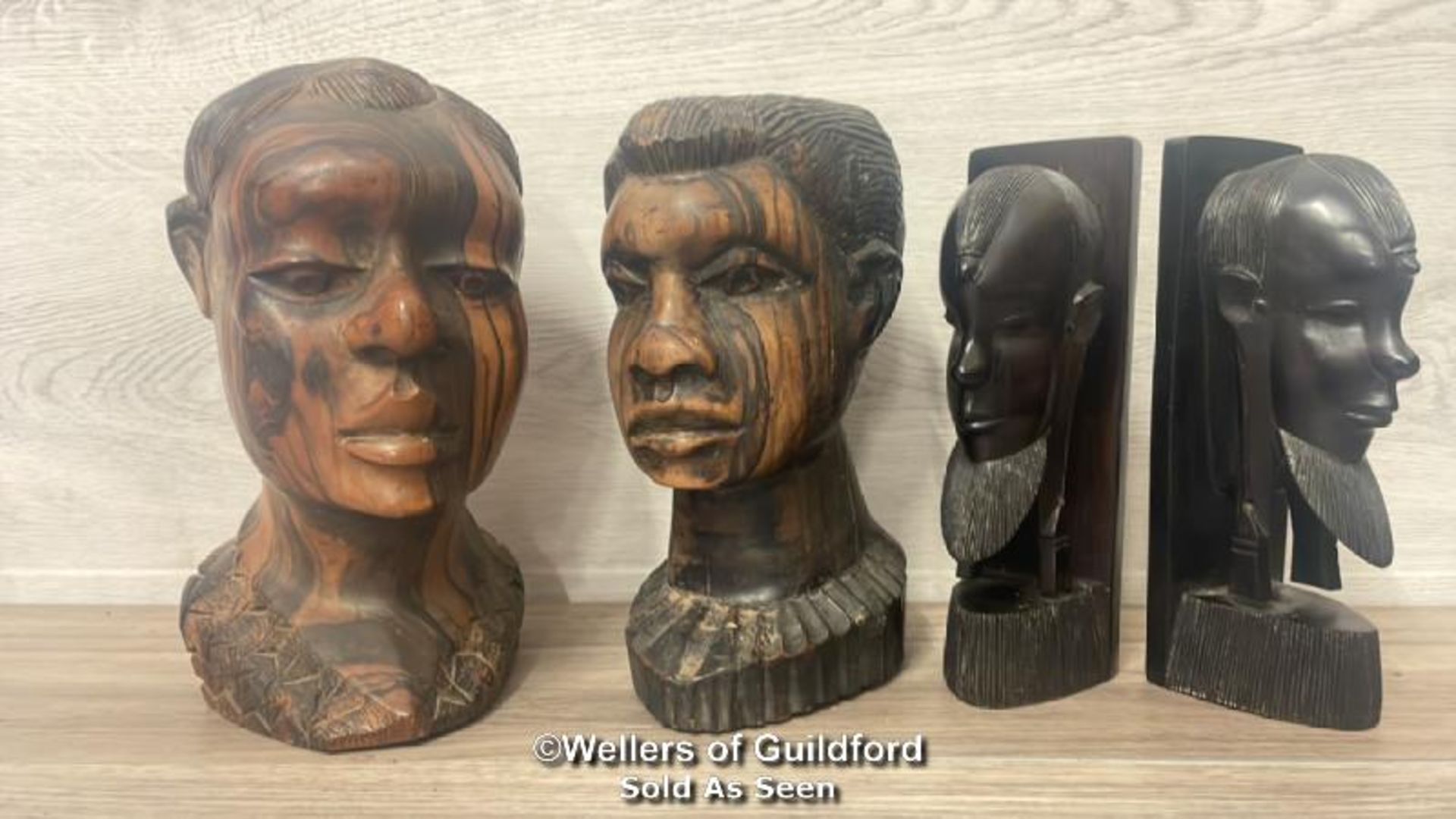 TWO CARVED AFRICAN HARDWOOD BUSTS, LARGEST 25.5CM HIGH AND A PAIR OF EBONY CARVED BOOKENDS WITH