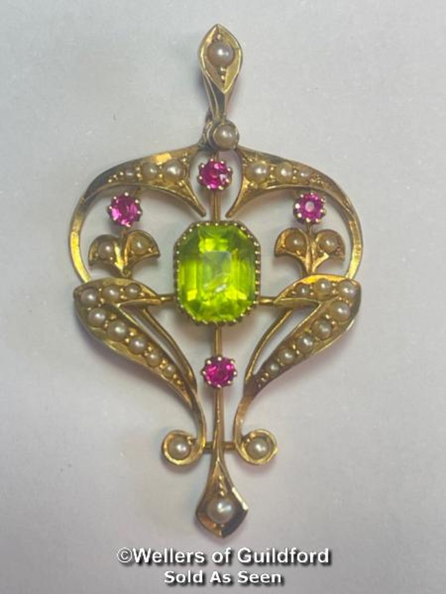 ART NOUVEAU PENDANT STAMPED 15CT SET WITH PERIDOT, RUBIES AND SPLIT SEED PEARLS. WEIGHT 3.9G,