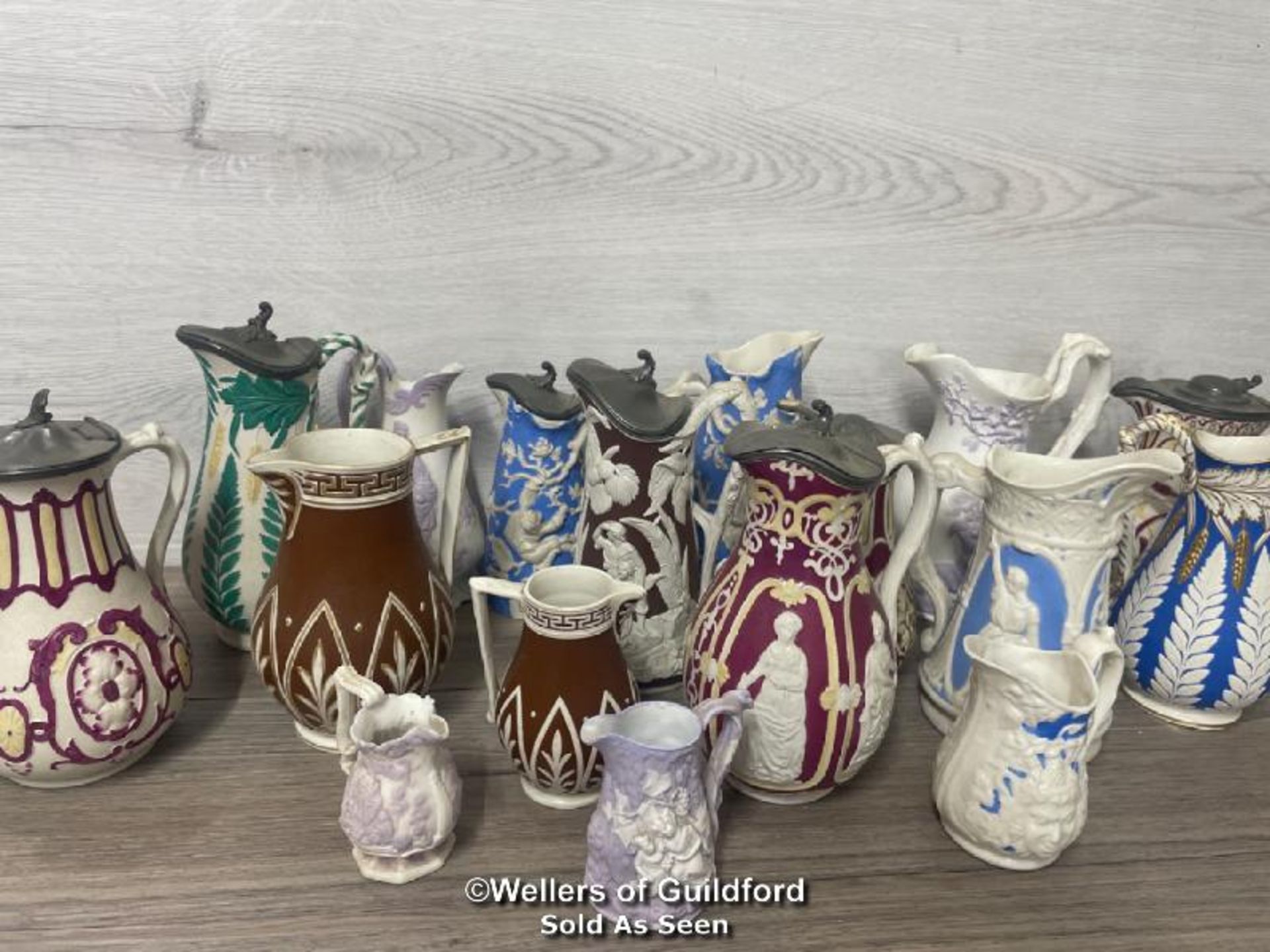 *A COLLECTION OF VICTORIAN JUGS, SOME RELIEF MOULDED, SOME WITH LIDS, SOME GRADUATED PAIRS