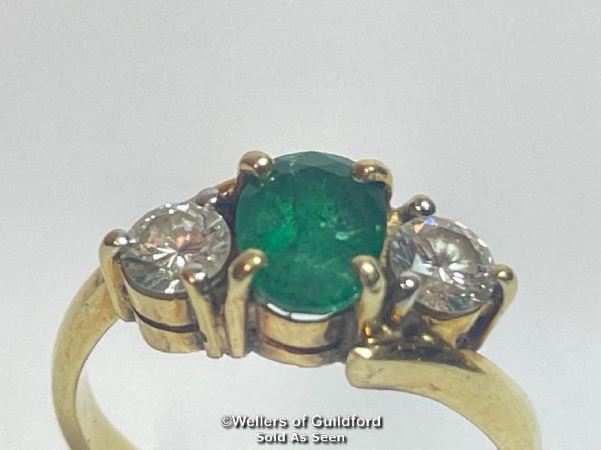 AN EMERALD AND DIAMOND THREE STONE RING IN CROSSOVER STYLE. EMERALD MEASURES APPROX 6.9 X 5.1 X 3. - Bild 2 aus 6