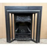 A reclaimed cast iron fireplace insert. The insert is complete and a restored reproduction