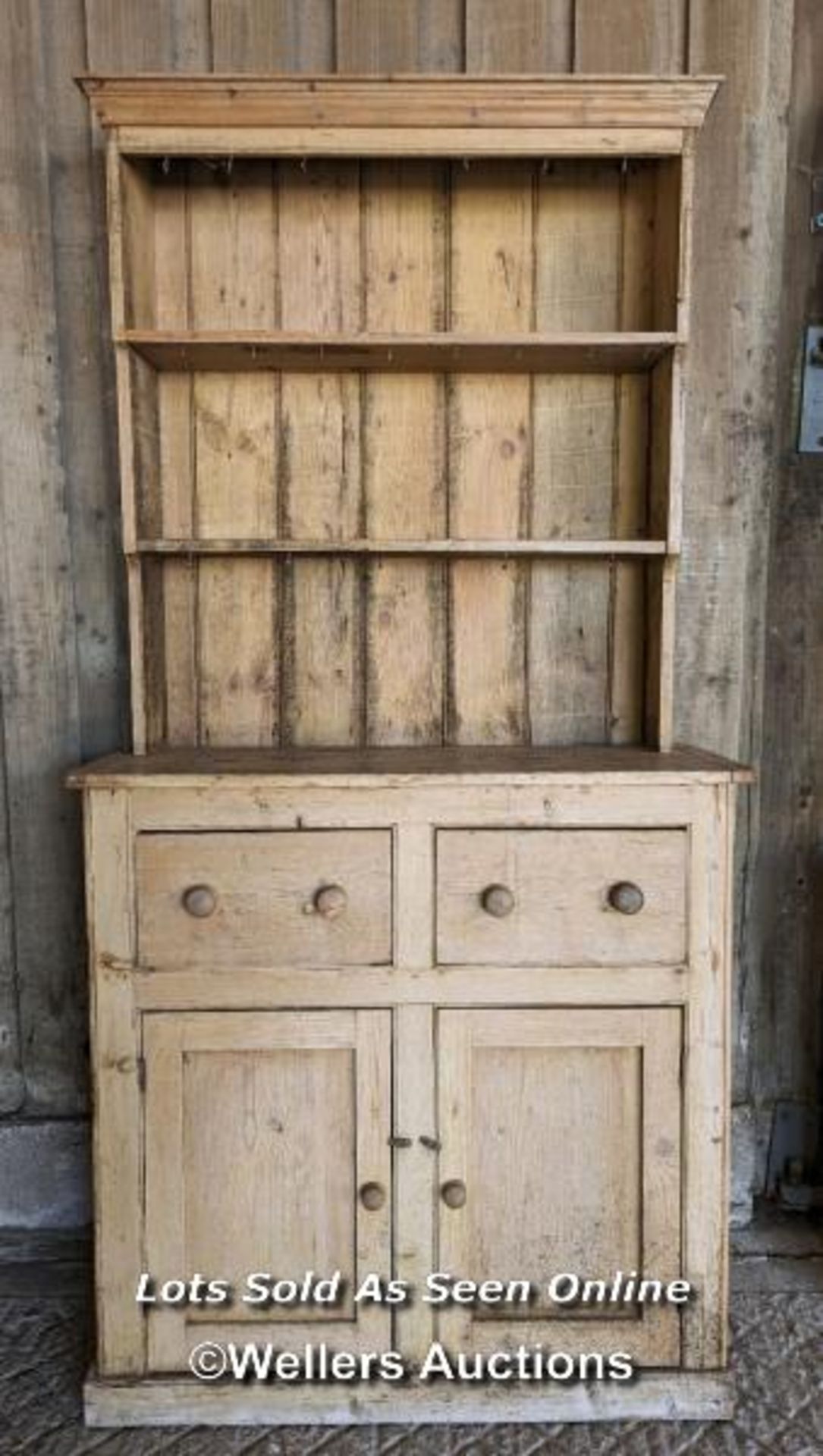 Stripped pine Victorian dresser for restoration. Open shelf over two drawers and two cupboards.