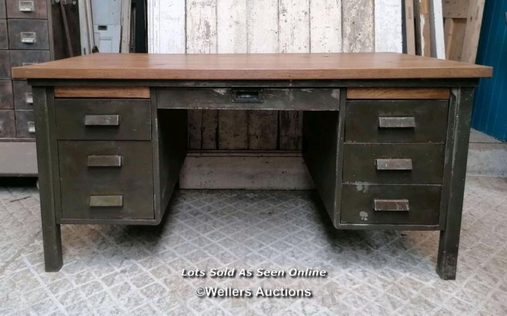 A vintage metal knee hole desk with later oak top. 157cm W x 76cm H x 89cm D. Some marks, ex shop