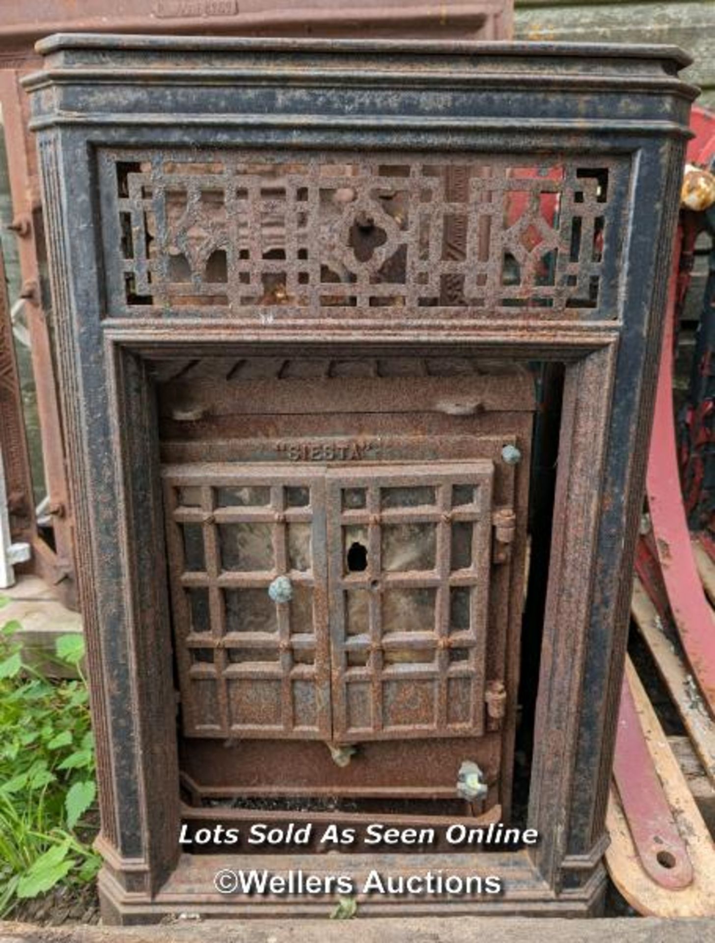 An Art Deco woodburning stove for restoration. Outer decorative removable frame in cast iron. 85cm H