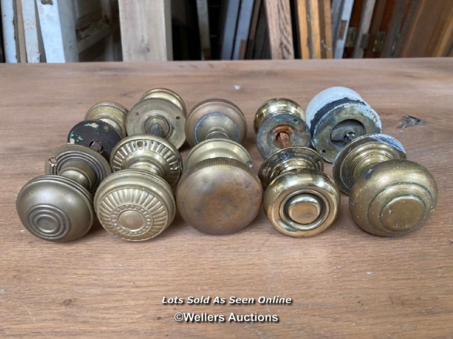 5 pairs of door handles. 4 pairs are brass and one pair is half brass and half wood. two