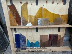 4 shelves of coloured glass pieces. Some textured pieces, some handpainted pieces.