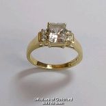 A cubic zirconia dress ring in hallmarked 14ct gold. The emerald cut centre stone measures 7mm x 5.