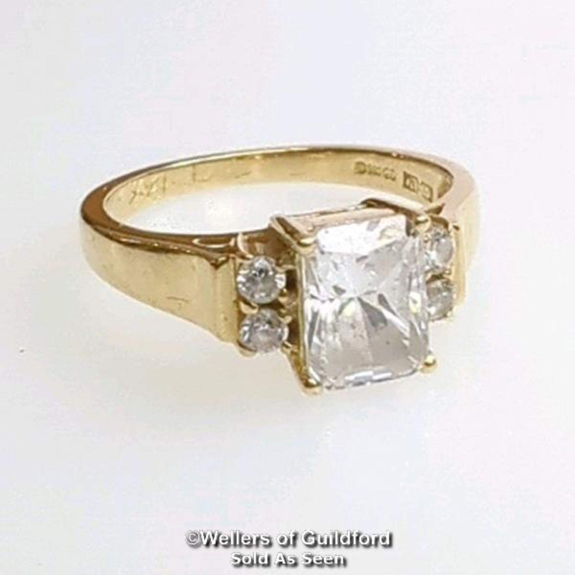 A cubic zirconia dress ring in hallmarked 14ct gold. The emerald cut centre stone measures 7mm x 5. - Image 4 of 8