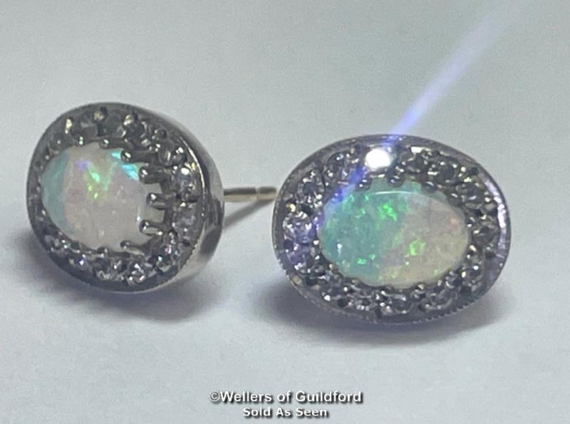 A pair of oval opal and diamond cluster earings in hallmarked 9ct gold. Opals measure approx 7mm x