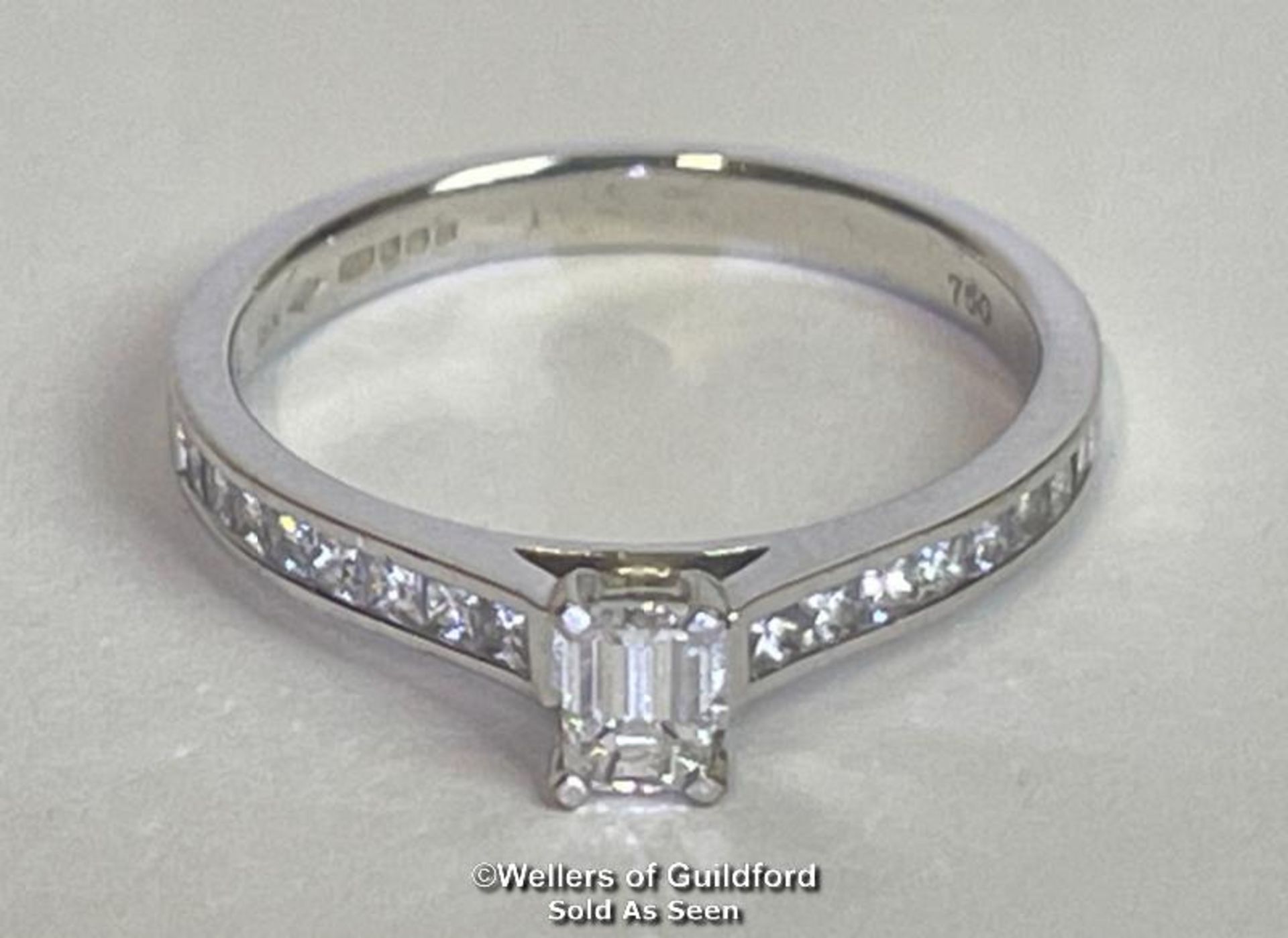 An emerald cut diamond solitaire ring with diamond shoulders, in hallmarked 18ct white gold. - Image 2 of 6