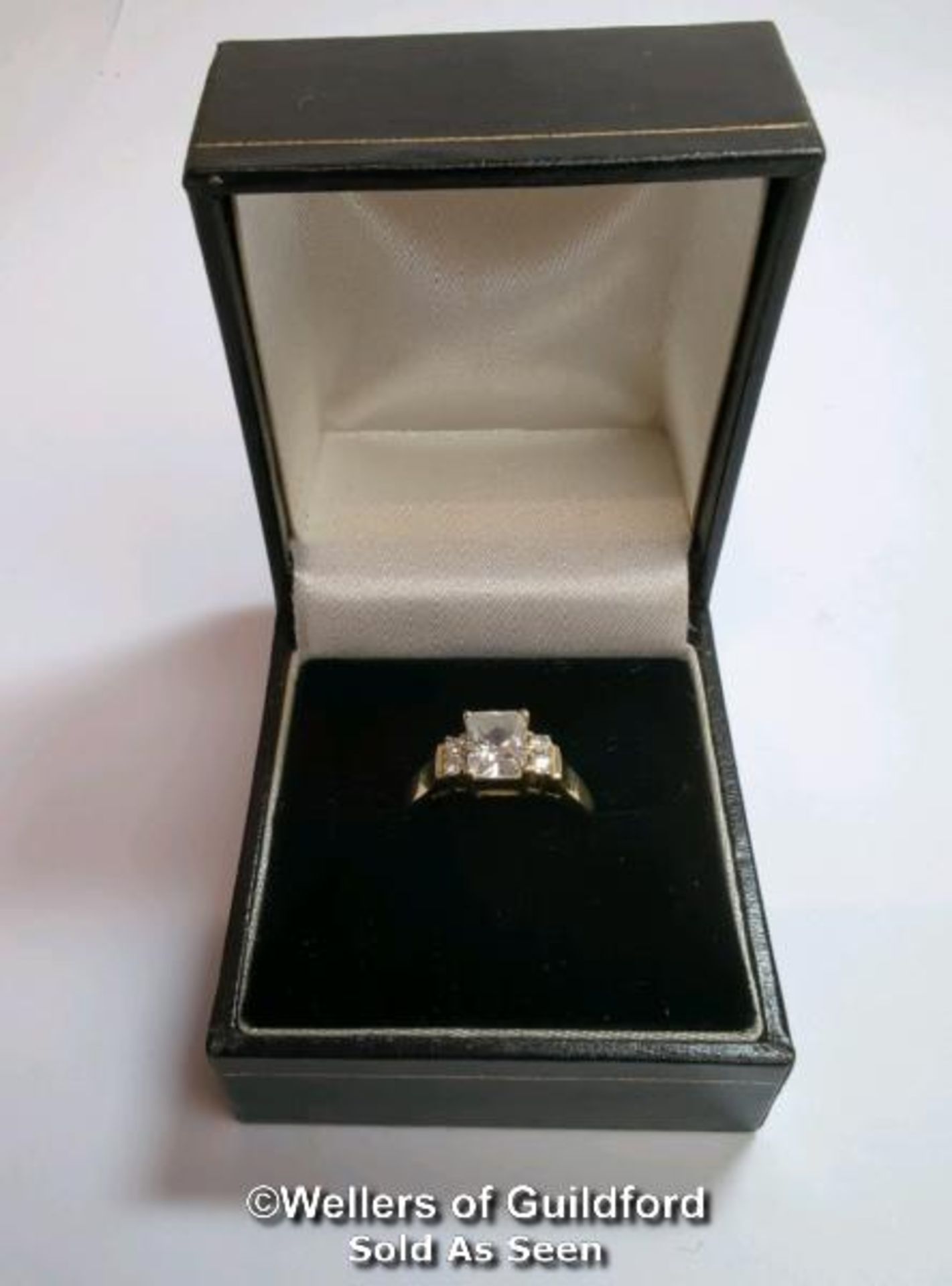 A cubic zirconia dress ring in hallmarked 14ct gold. The emerald cut centre stone measures 7mm x 5. - Image 8 of 8