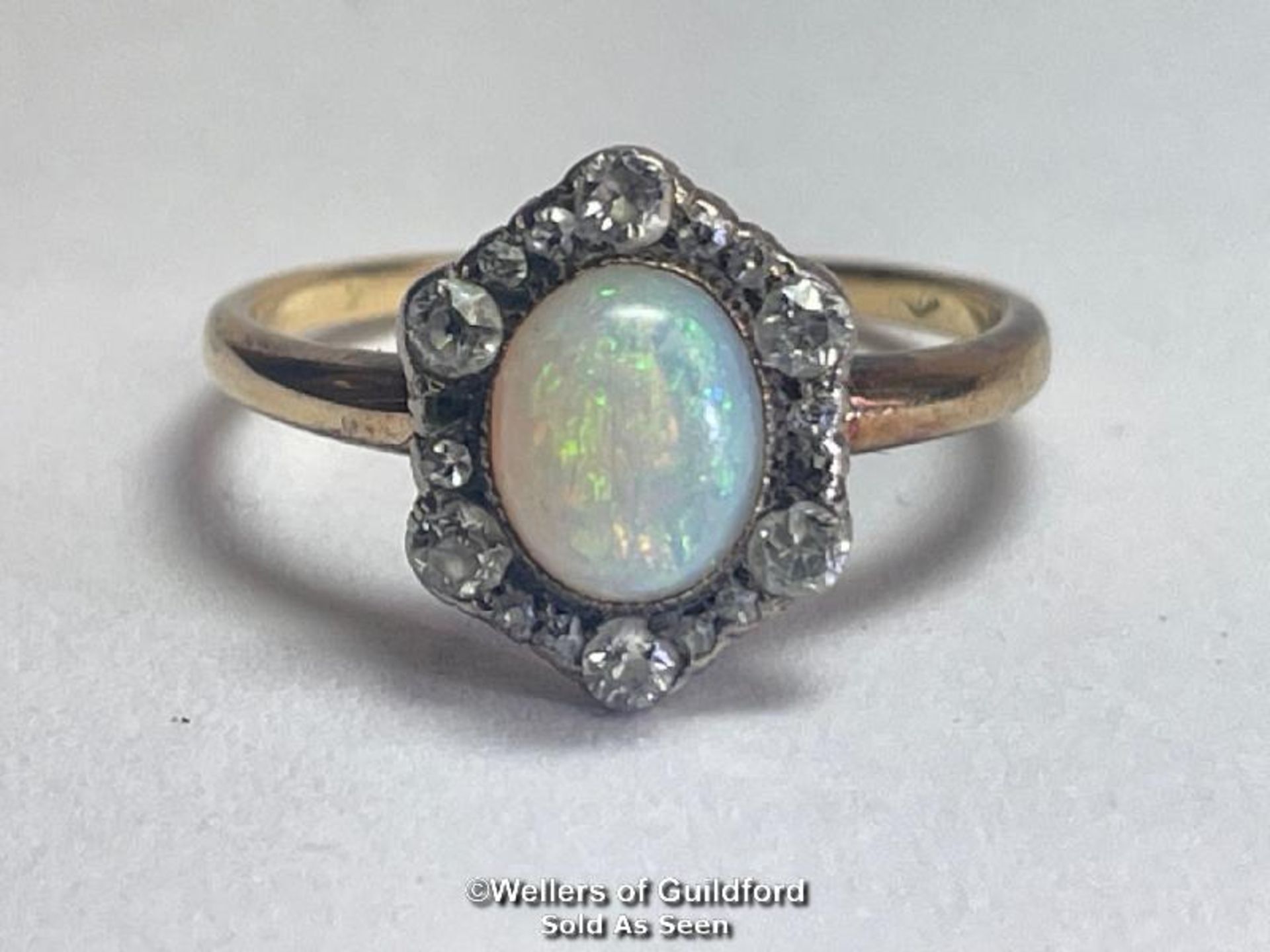 Opal and diamond cluster ring. An oval opal surrounded by a border of old cut diamonds forming a - Image 2 of 4