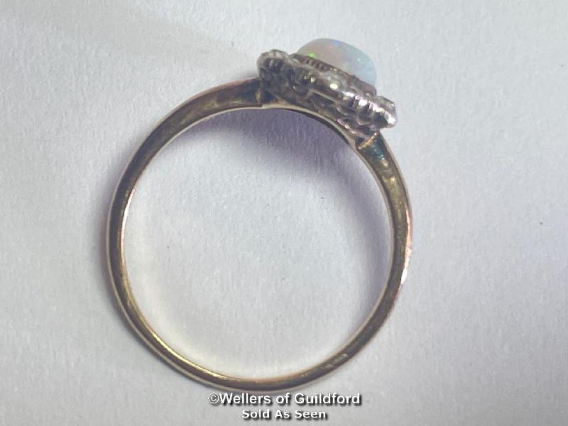 Opal and diamond cluster ring. An oval opal surrounded by a border of old cut diamonds forming a - Image 3 of 4